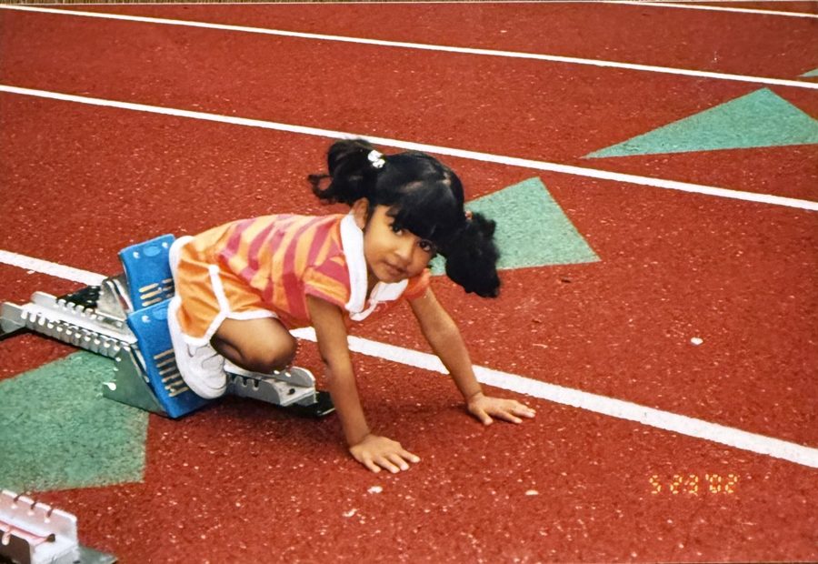 Toddler Sejal in the starting blocks on a red track