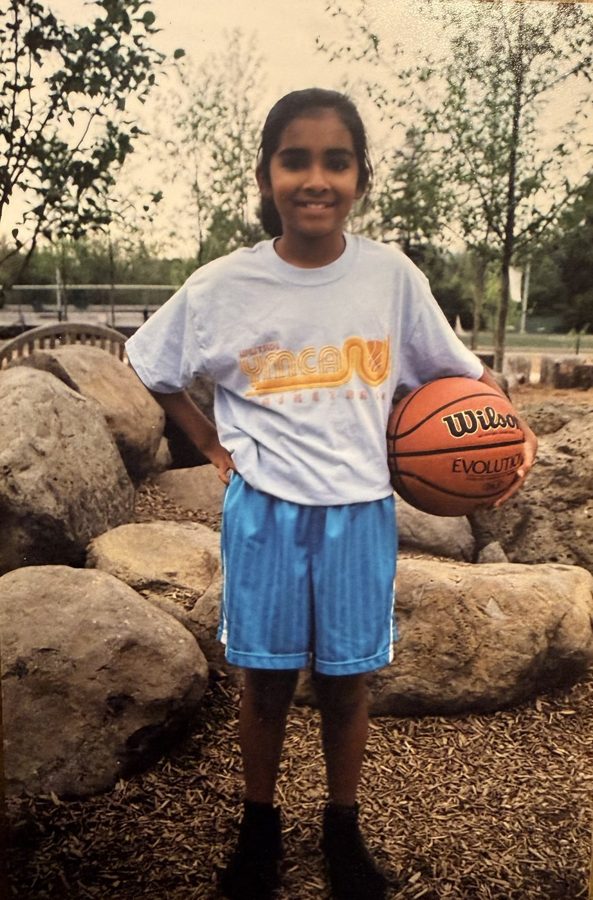 Young Sejal holding a Wilson basketball in a YMCA tee