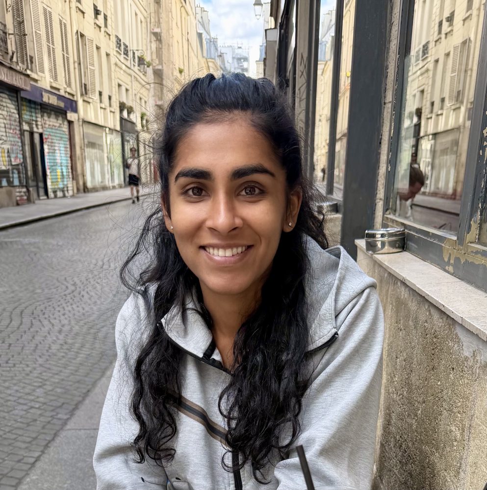 Sejal Dua smiling on a cobblestone street in Paris